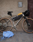 Bicycle with gear packs and a blue bag on a sidewalk