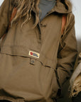 Brown jacket with a visible Fjällräven label on a blurred background