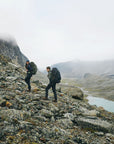 two men trekking upslope on rocky pavement