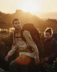 a couple carrying trekking backpacks and trekking in the mountains