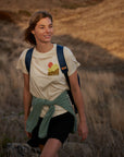 woman in white t-shirt trekking on grass patch