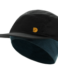 Two-tone black and blue cap with a yellow Fjällräven logo on a white background