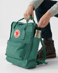 Pulling a bottle out of a Fjällräven Kånken backpack