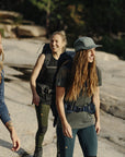 women carrying trekking backpack and wearing t-shirts and winter jackets on a trek