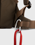 Brown backpack with a carabiner and red rope on a white background