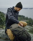 Man sitting on a rock with a backpack outdoors