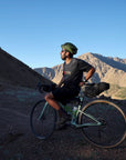 Man with a bicycle in a mountainous desert landscape