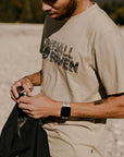 man wearing fossil round neck t-shirt on a sandy beach