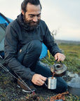 man pouring coffee on a hiking camping trip