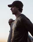 man wearing long sleeve top and a cap, wearing a jacket