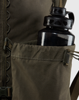 Black water bottle in a brown backpack pocket with a white background