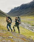 two men carrying trekking backpack trekking on a mountain