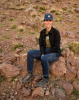 Person sitting on rocks in a desert landscape