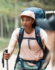 Woman hiking with a backpack and walking stick on a trail