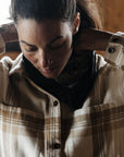 woman adjusting collar of checkered shirt