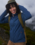 woman wearing indigo blue jacket hiking on the mountain