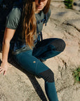 woman wearing blue tights bending down with reinforced knees and Fjällräven logo