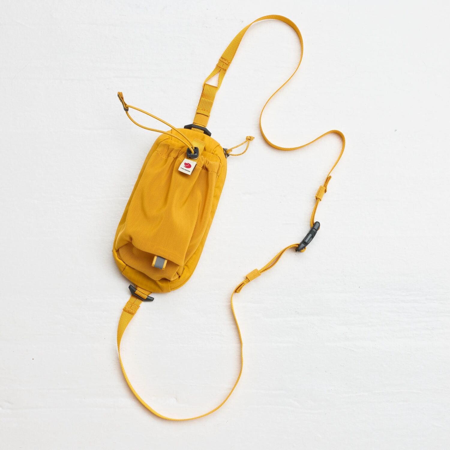 Yellow waist bag with a long strap on a white background