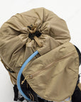 Beige compression sack with a blue hydration bladder on a white background