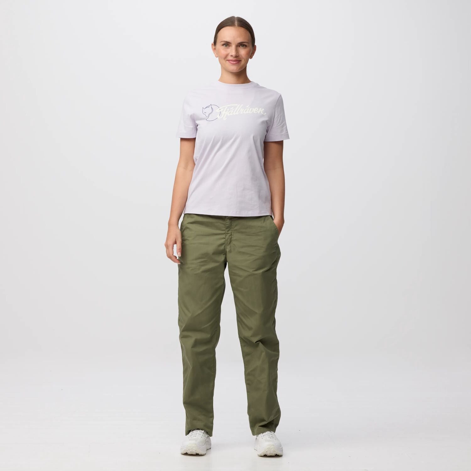 Person wearing a light gray t-shirt and green pants on a white background