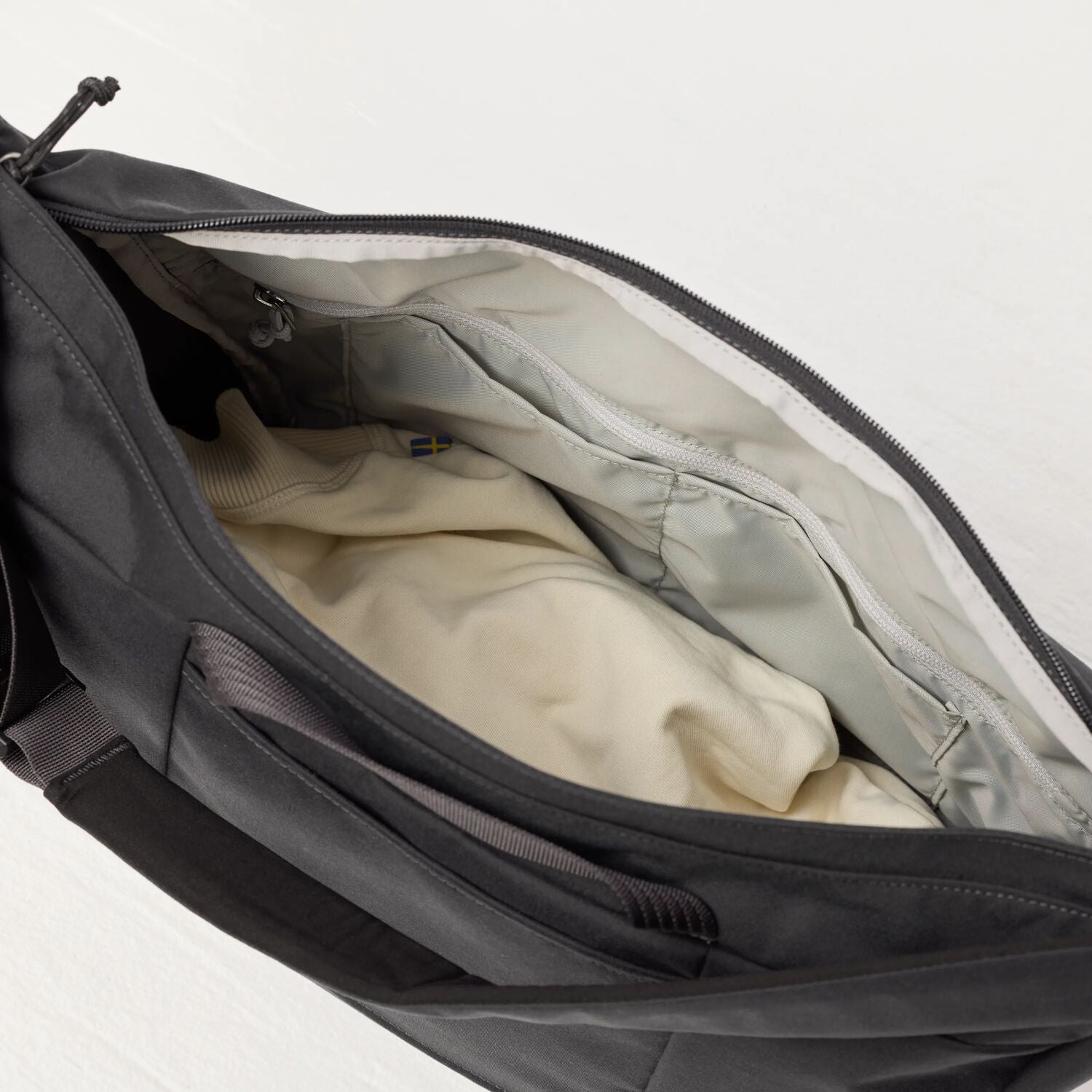 Gray bag with beige interior lining on a light gray background