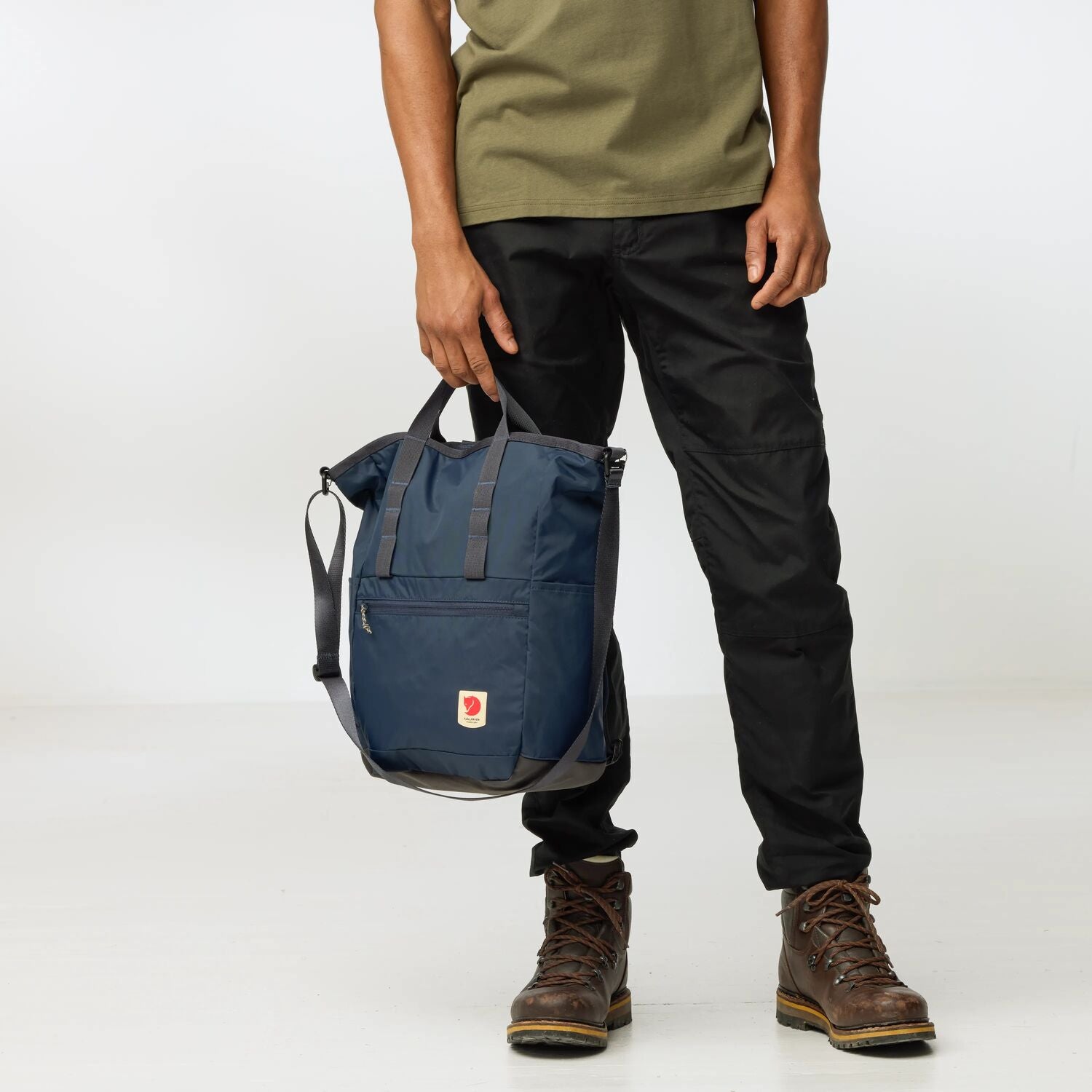 Person holding a navy blue backpack with a white background