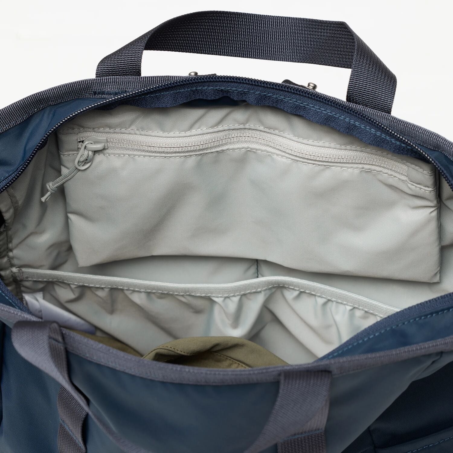 Open blue backpack with beige interior on a white background