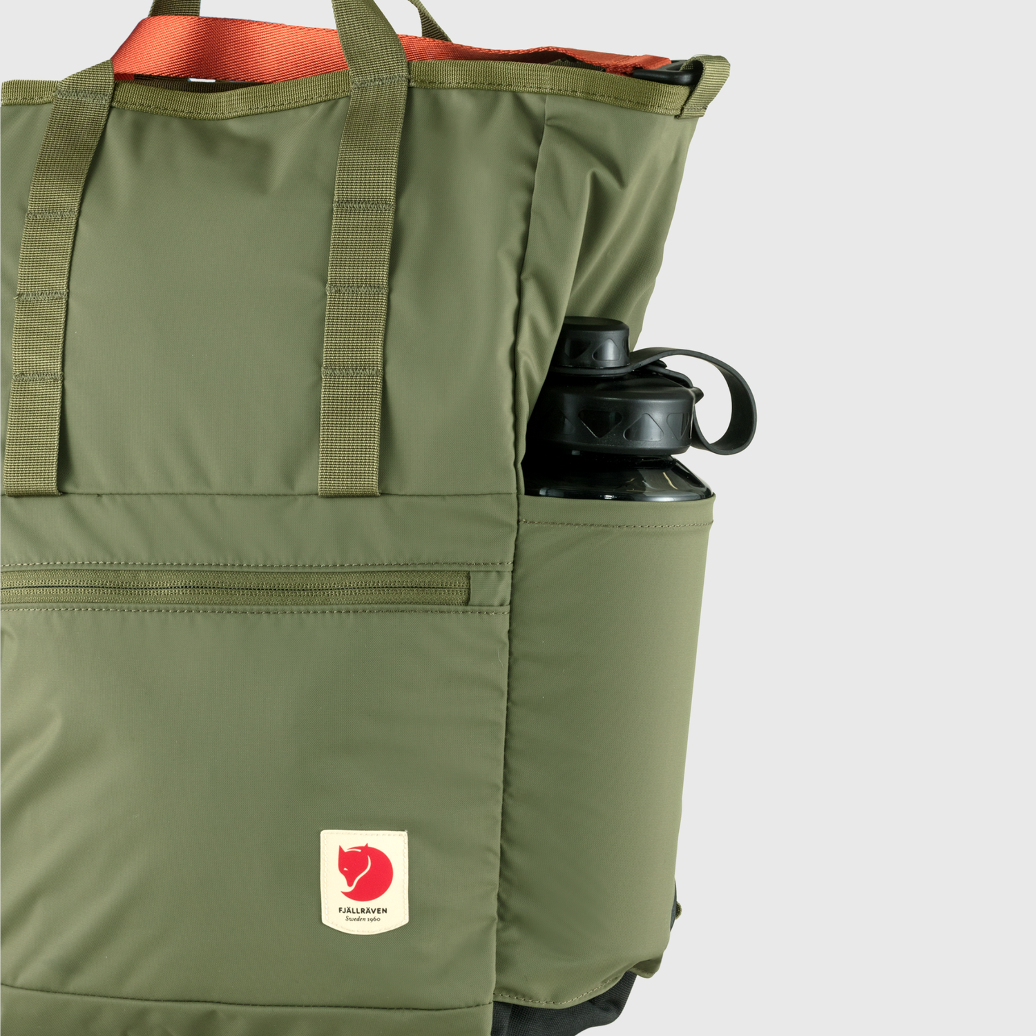 Green backpack with a water bottle in the pocket on a light gray background