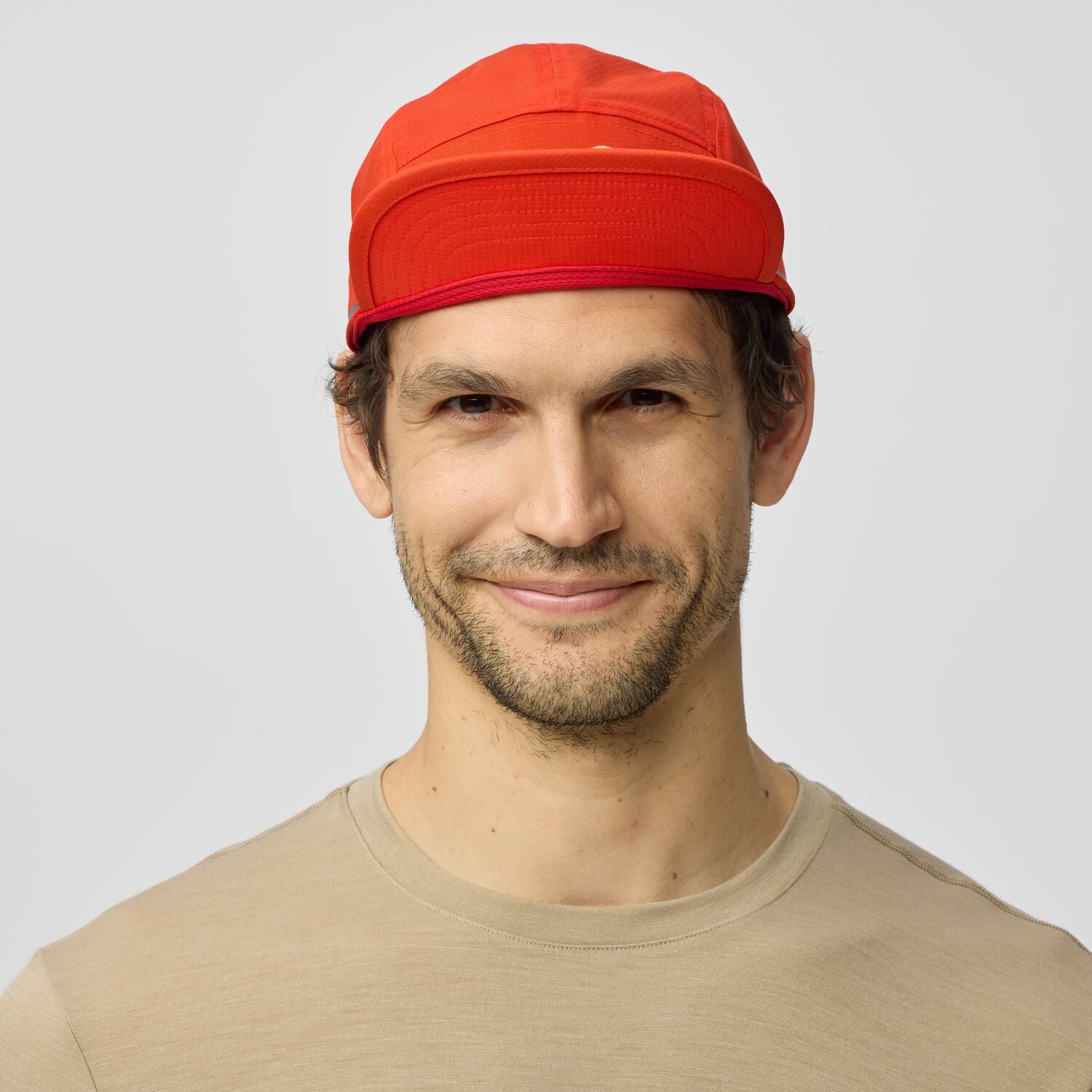 Man wearing a red cap against a plain background