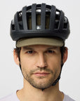 Man wearing a black helmet and green cap on a white background
