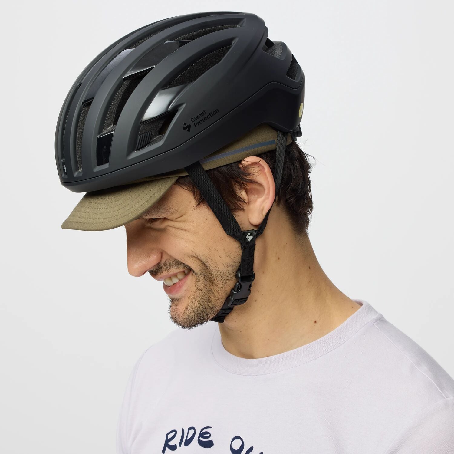 Man wearing a black helmet and white t-shirt with 'RIDE' text on a light gray background