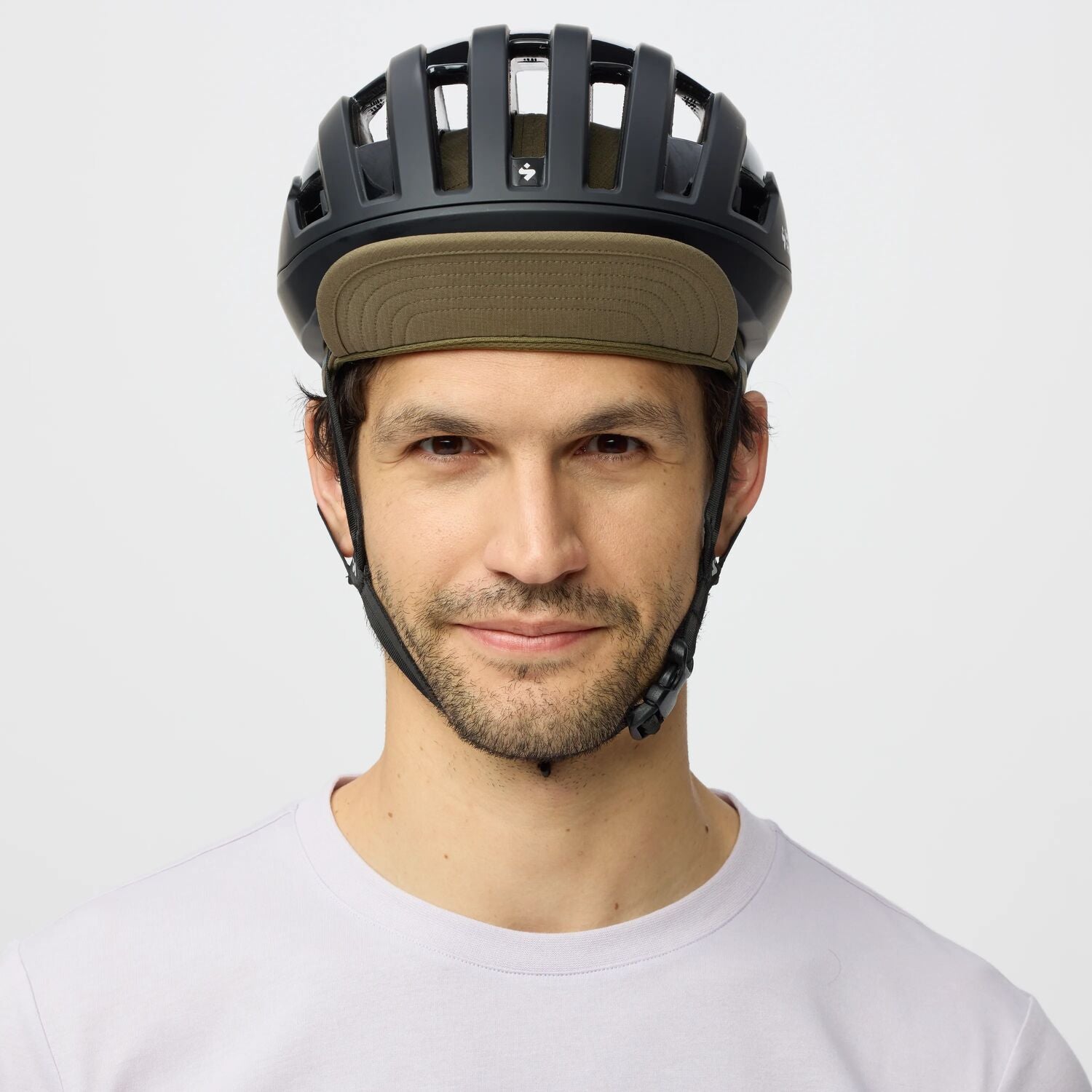 Man wearing a black helmet with a green cap on a white background