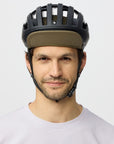 Man wearing a black helmet with a green cap on a white background