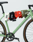 Set of colorful socks hanging on a green bicycle against a light gray background