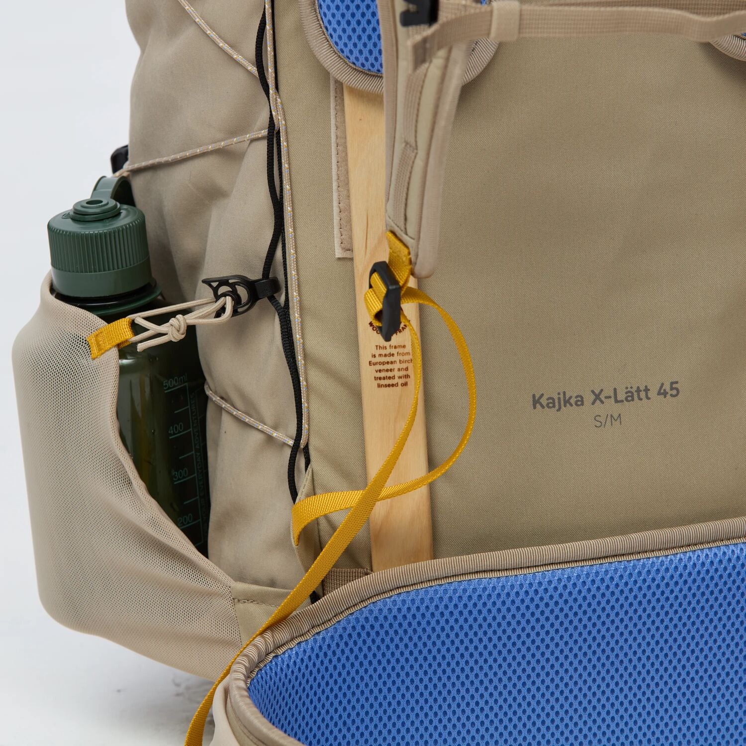 Close-up of a beige backpack with blue cushion and water bottle holder.