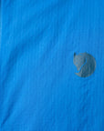 Close-up of a blue fabric with a logo on a jacket