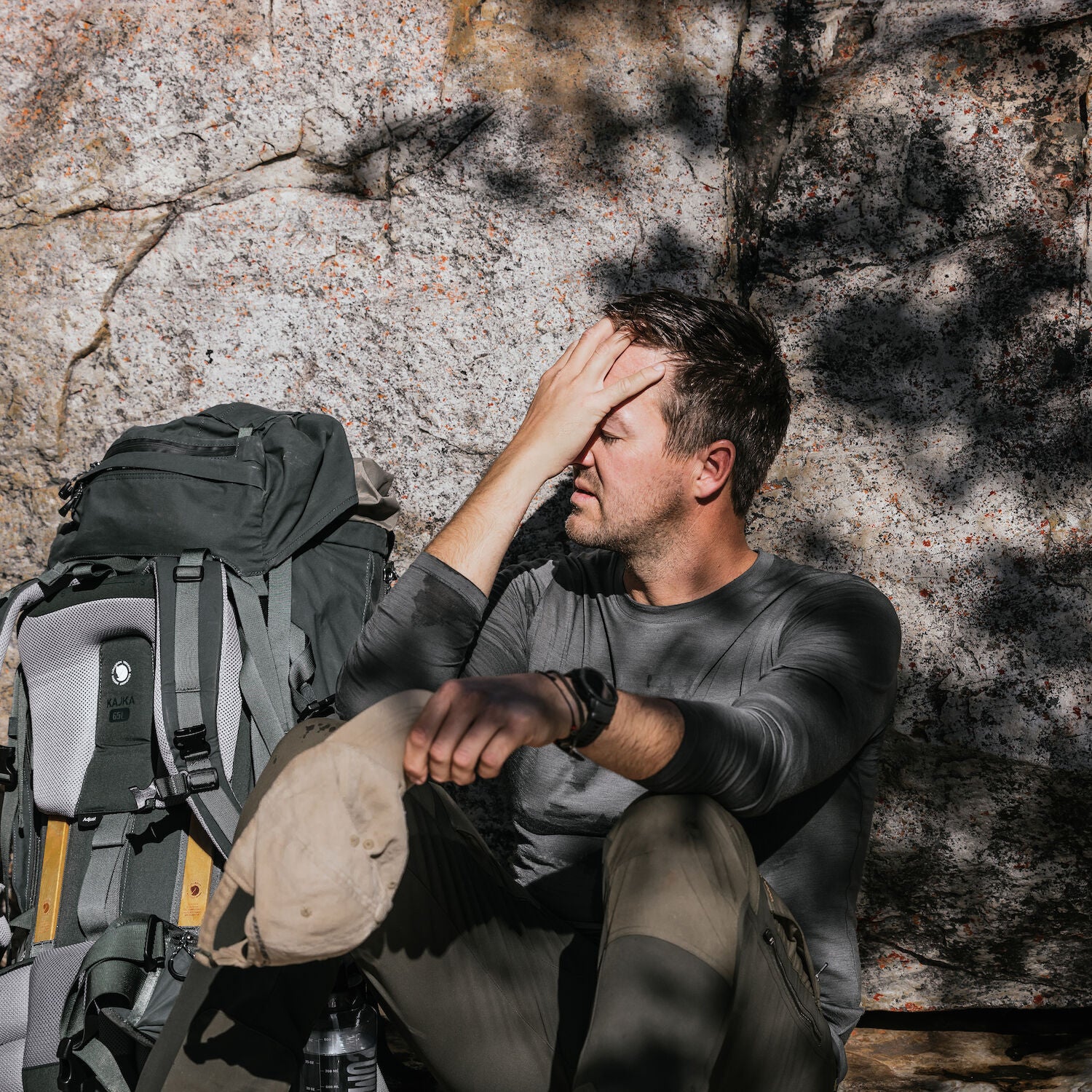 man in basalt winter long john resting on mountain