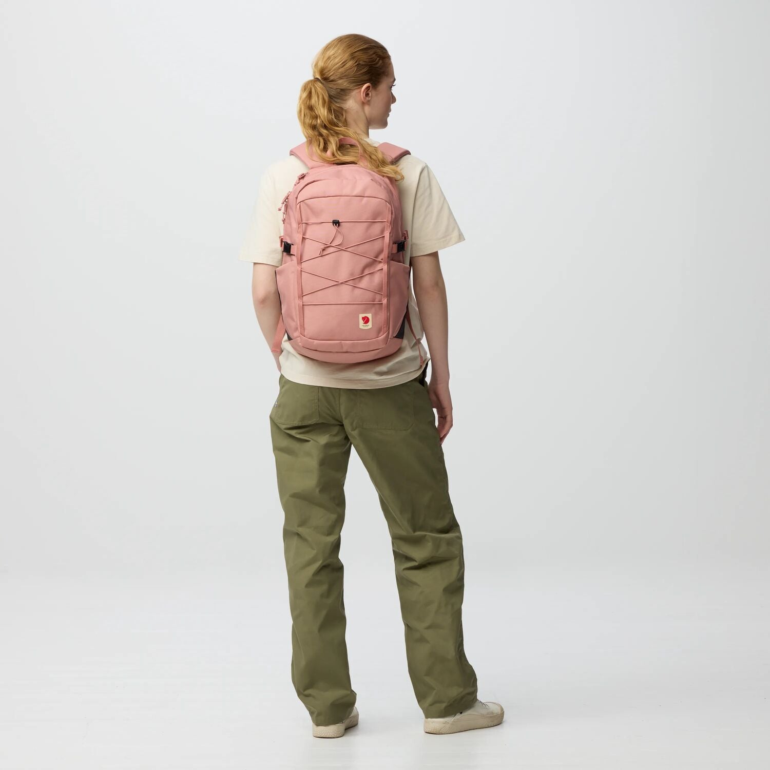 Person wearing a pink backpack on a white background