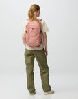 Person wearing a pink backpack on a white background