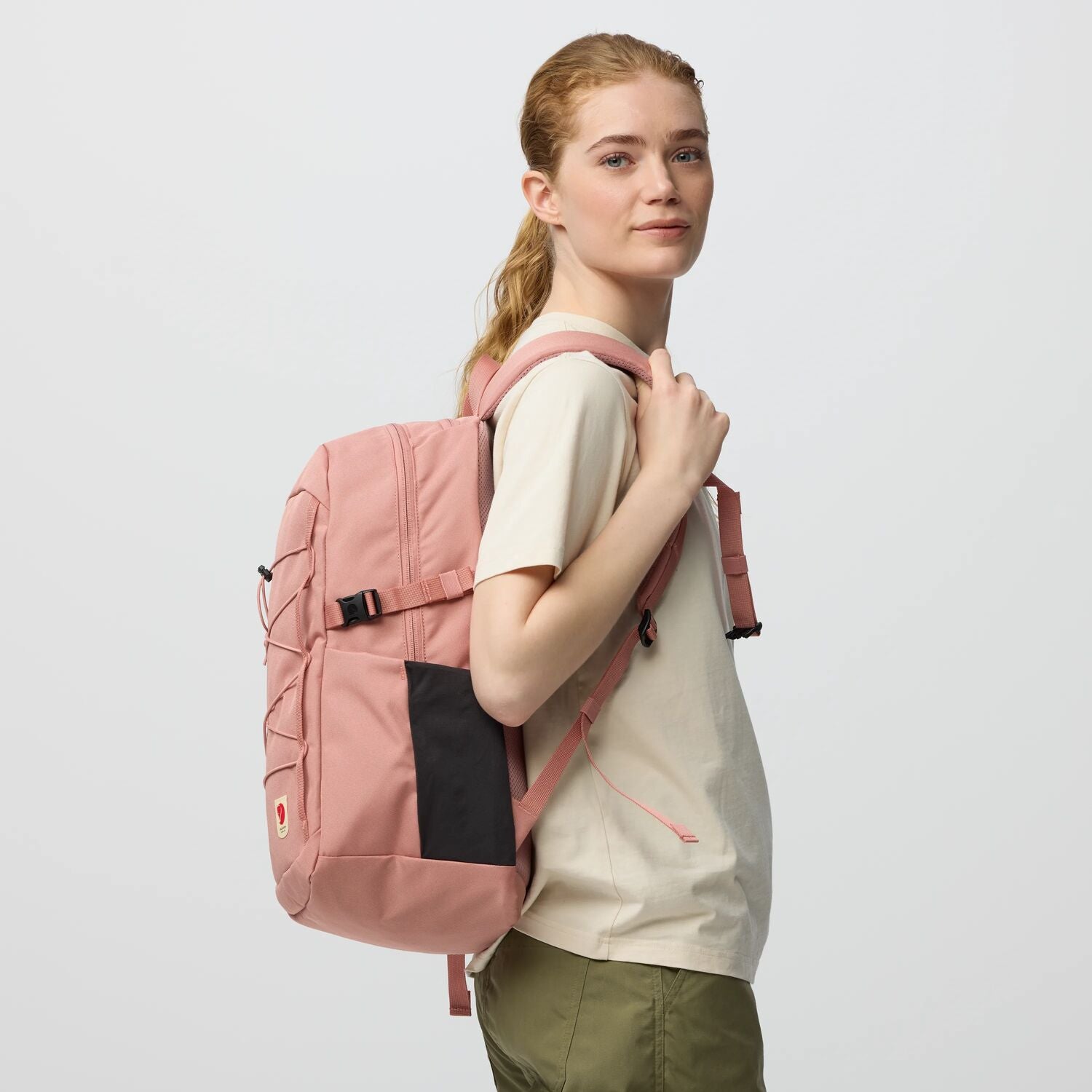 Person wearing a pink backpack on a light gray background