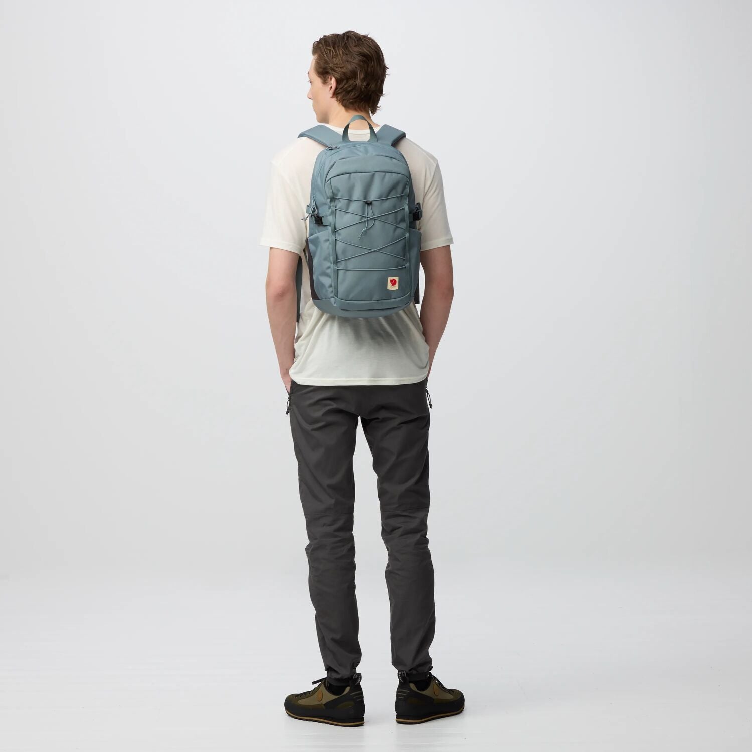 Person wearing a blue backpack on a white background