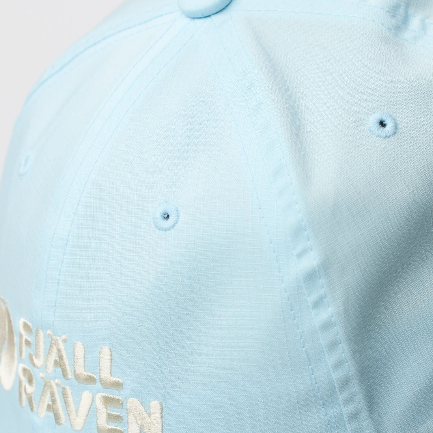 Light blue cap with 'Fjällräven' branding on a light background
