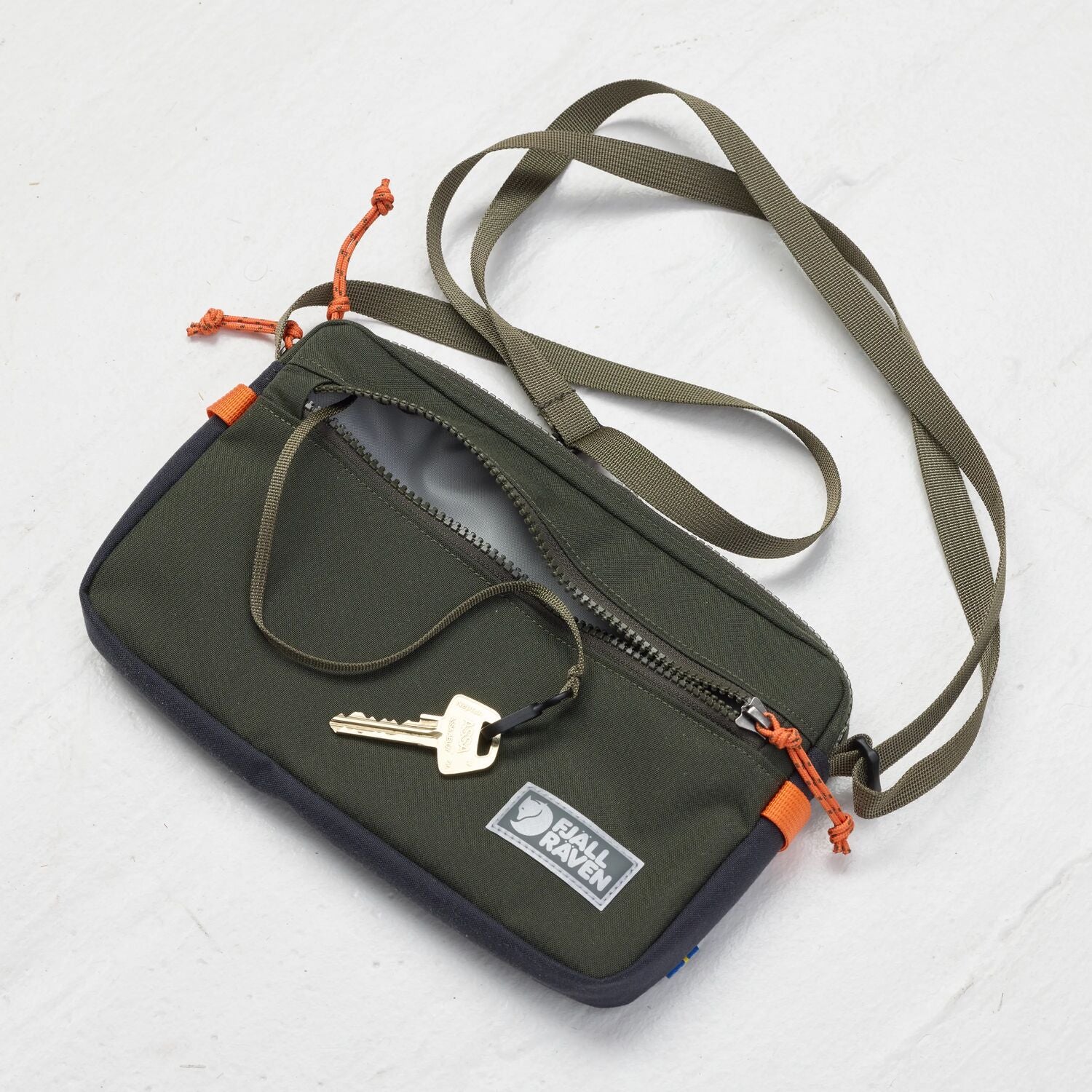 Green crossbody bag with keys on a white background