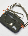 Green crossbody bag with keys on a white background