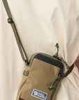 Brown crossbody bag with visible Fjällräven logo worn over a beige shirt.