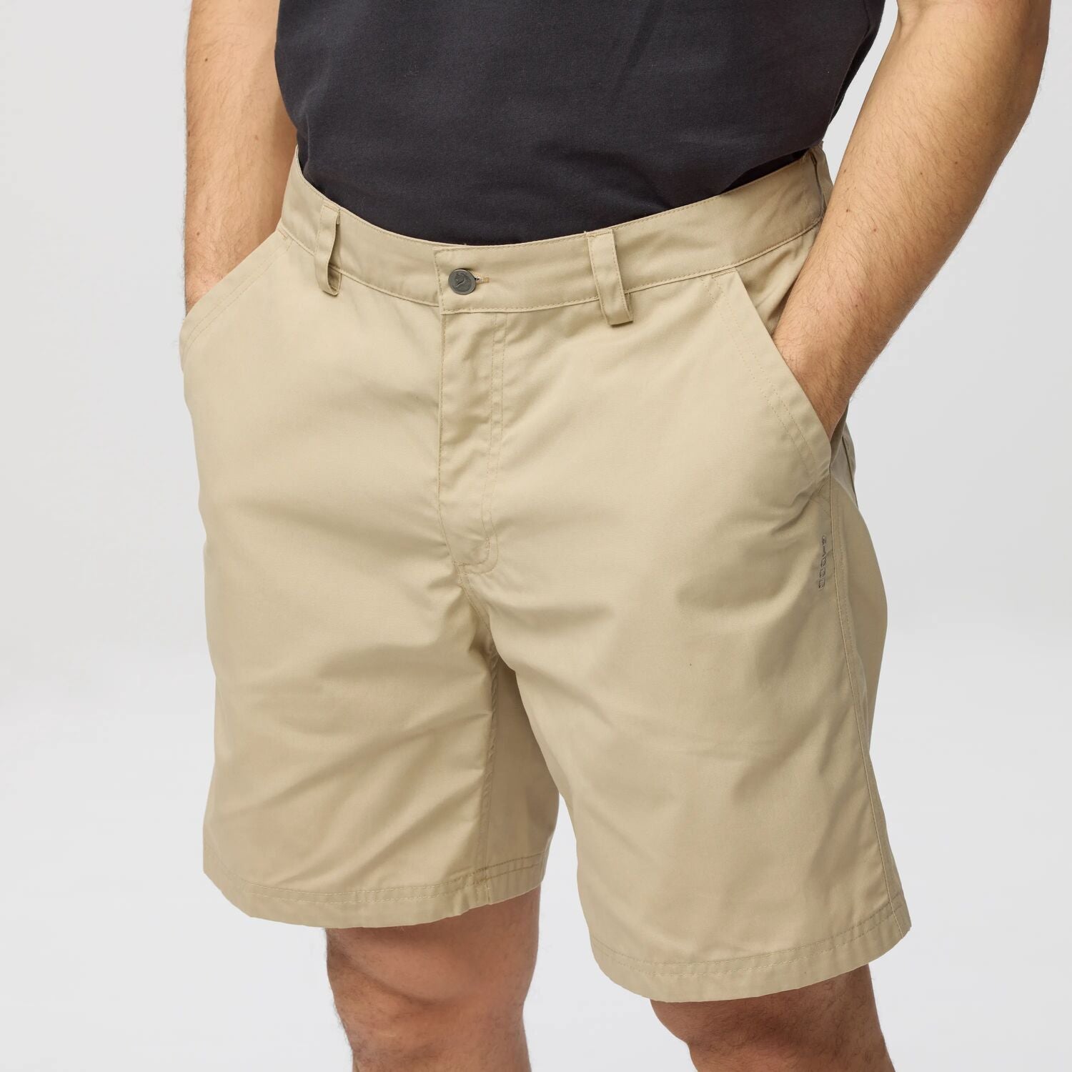 Beige shorts worn by a person on a plain background