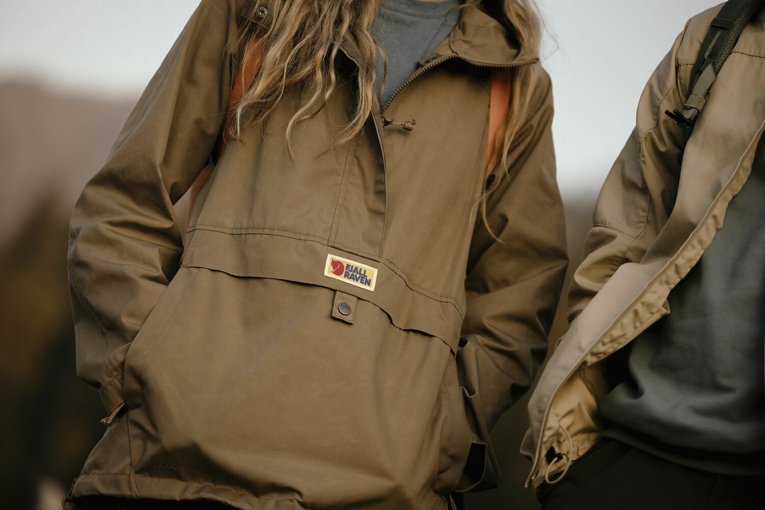 Brown jacket with a visible Fjällräven label on a blurred background