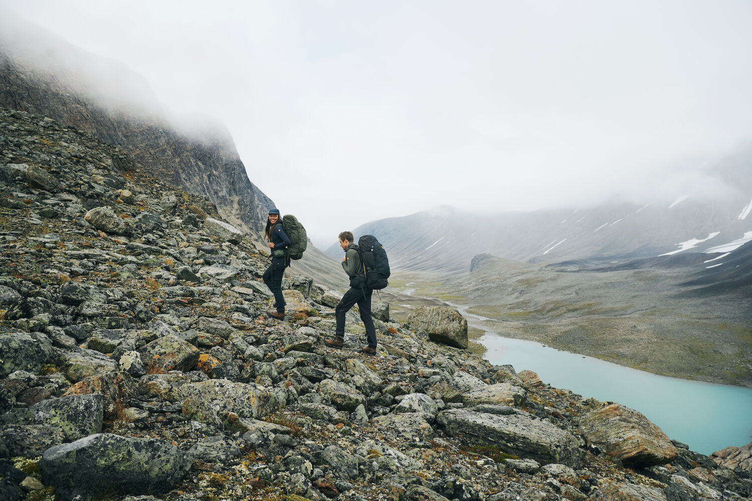 two men trekking upslope on rocky pavement