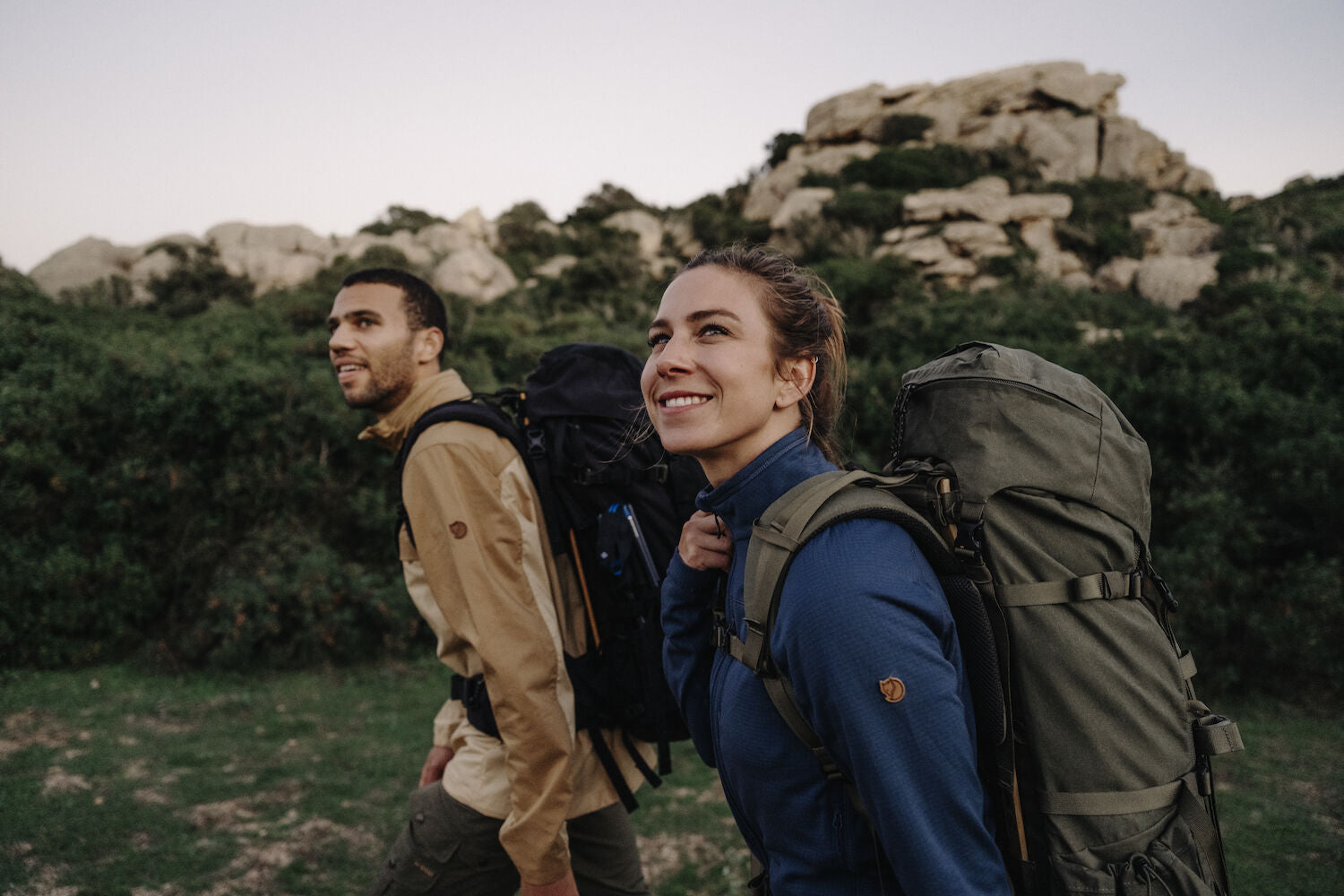 couple carrying trekking backpacks and trekking in the mountains