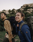 couple carrying trekking backpacks and trekking in the mountains